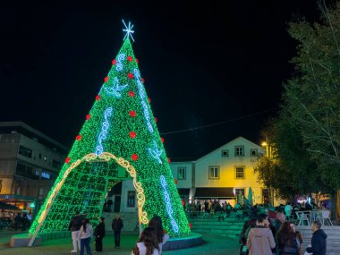 Santa Maria da Feira, Portekiz - 30 Kasım 2024. Noel ışıklarıyla süslenmiş eski şehir sokaklarına bir aylağın bakış açısı. Perlim tema parkındaki dekorasyon aynı kalıyor..