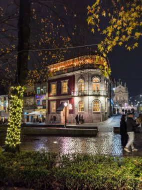 Porto, Portekiz - 9 Aralık 2023. Cordoaria Bahçesi Noel Pazarı 'nın gece manzarası. Yöre sakinleri ve ziyaretçiler Noel ışıklarını ve orkestranın ışıklarla süslendiğini görmek için sokaklarda yürüyorlar.