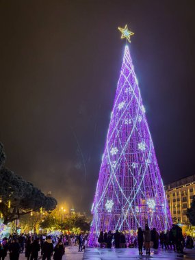 Porto, Portekiz - 9 Aralık 2023. Avenida dos Aliados ve Belediye Binası 'nın gece sahnesi Noel ağacıyla. Yöre sakinleri ve ziyaretçiler Noel ışıklarını ve belediye binasının önündeki büyük Noel ağacını görmek için caddelerde yürüyorlar.