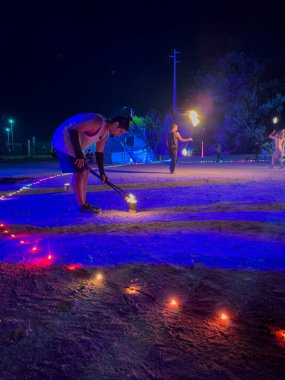 Ovar, Portugal - July 28, 2024: Jugglers of various nationalities practice fire juggling at night clipart