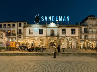 Gaia, Portugal - November 28, 2024: The iconic Sandeman Cellars building, illuminated against the night sky, stands proudly in Vila Nova de Gaia, a testament to Portugal s rich winemaking history. clipart