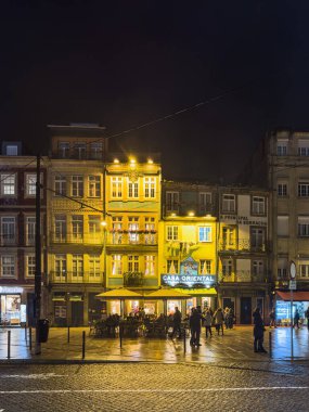 Porto, Portugal - December 9, 2023. Close to Torre dos Clerigos, Casa Oriental is a grocery store founded in 1910, which began selling products from the Eastern and African colonies. Recently associated with Comur - canned sardine store. Night scene. clipart