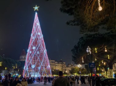 Porto, Portekiz - 9 Aralık 2023. Avenida dos Aliados ve Belediye Binası 'nın gece sahnesi Noel ağacıyla. Yöre sakinleri ve ziyaretçiler Noel ışıklarını ve belediye binasının önündeki büyük Noel ağacını görmek için caddelerde yürüyorlar.