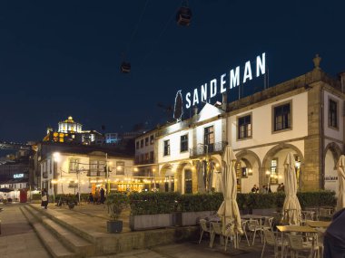 Gaia, Portugal - November 28, 2024: The iconic Sandeman Cellars building, illuminated against the night sky, stands proudly in Vila Nova de Gaia, a testament to Portugal s rich winemaking history. clipart