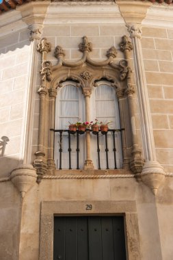 Evora 'daki güzel pencereli Portekiz cephesi. Portekiz 'in Evora şehrinde manueline tarzı pencereli tipik Portekiz cephesi