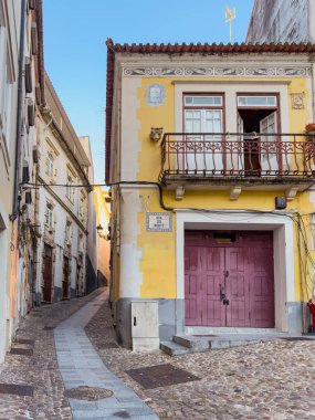 Old and narrow street in historical center of Coimbra, Portugal clipart