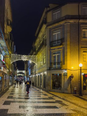 Porto, Portekiz - 9 Aralık 2023. Cedofeita Caddesi 'nin gece manzarası. Yöre sakinleri ve ziyaretçiler Noel ışıklarını ve belediye binasının önündeki büyük Noel ağacını görmek için caddelerde yürüyorlar.
