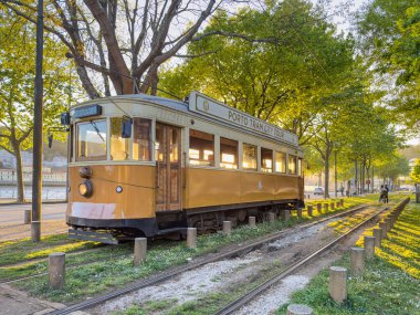 PORTO, PORTUGAL - 5 Nisan 2023: Porto caddesinde hareket eden ahşap tarihi klasik tramvay, şehrin sembolü. Massarelos 'ta gün batımında arka planda Arrabida köprüsü olan eski bir tramvay geçiyor. Portekiz