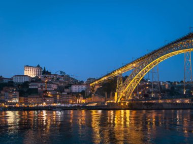 Gece gökyüzüne karşı aydınlanan ikonik Dom Luis Köprüsü Porto 'nun endüstriyel mirasının ve mimari güzelliğinin bir sembolü olarak duruyor..
