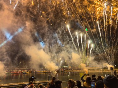 Aveiro, Portekiz - 01 Aralık 2023. Portekiz 'in Aveiro kentindeki aydınlık Noel ağacının üzerindeki canlı havai fişekler bu büyüleyici sahil şehrinde festival sezonunun başlangıcını simgeliyor..