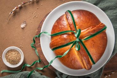 Paskalya masasında yumurtasız, yeşil kadife fiyonklu ve rezene tohumlu Portekiz geleneksel Paskalya pastası. Üst görünüm