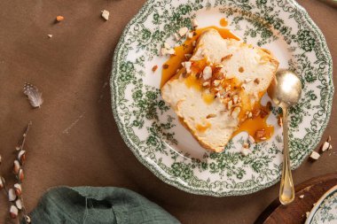 Üst manzara, üzerinde şerbet ve badem parçaları bulunan ve yanında altın bir kaşık bulunan dekoratif bir tabakta duran Molotof veya molotof olarak bilinen geleneksel karamelize edilmiş yumurta beyaz pudingini gösteriyor.