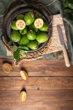 Olgun ananas guava ile kırsal bir yaşam, bazı kesikler küçük bir tabak ve bir sepet içinde etli posa ortaya çıkarmak için açık