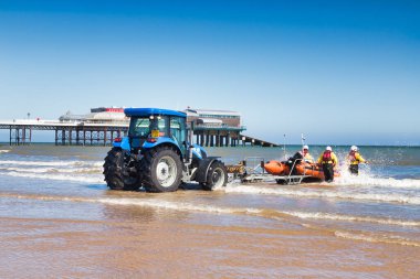 30 June 2019: Cromer, Norfolk, UK - RNLI inshore lifeboat being pushed out into sea during training exercise.