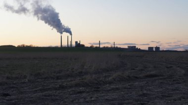 Kışın gün batımında santralden duman çıkıyor.