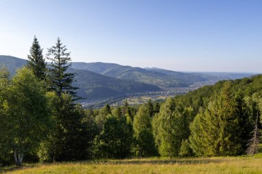Yeşil ormanlarla, yuvarlanan tepelerle nefes kesen bir dağ vadisi ve açık mavi bir yaz gökyüzünün altında yuva yapmış bir köy.