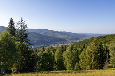 Yeşil ormanlarla, yuvarlanan tepelerle nefes kesen bir dağ vadisi ve açık mavi bir yaz gökyüzünün altında yuva yapmış bir köy.