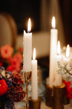 Çiçekler ve mumlarla düğün masası.