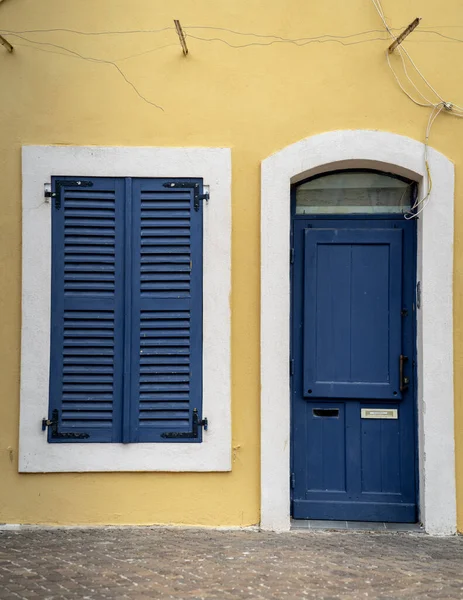 Blaue Türen Und Fenster Des Gelben Hauses Stockbild