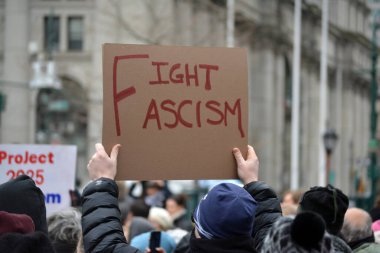 2025 Halk Yürüyüşü 'nde New York' taki Trump yönetimine karşı bir tabela tutan protestocu..