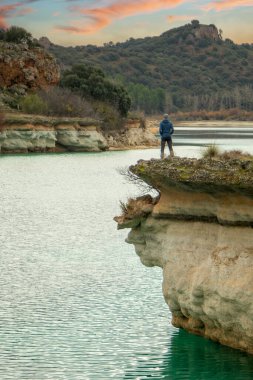 İspanya 'nın Ruidera gölünde tek başına bir uçurumdan gölü seyreden ve doğanın tadını çıkaran biri. Rahatlamak için yalnız seyahat ediyorum..