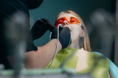 Dişçi bir kıza implant yerleştiriyor.