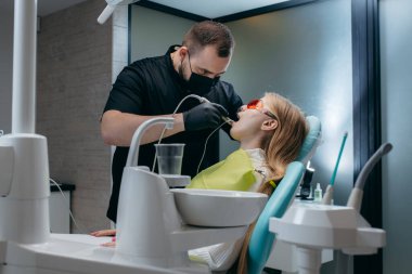 Dişçi bir kıza implant yerleştiriyor.