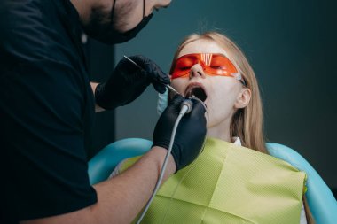 Dişçi bir kıza implant yerleştiriyor.