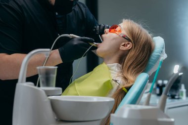 Dişçi bir kıza implant yerleştiriyor.