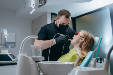 Dişçi bir kıza implant yerleştiriyor.