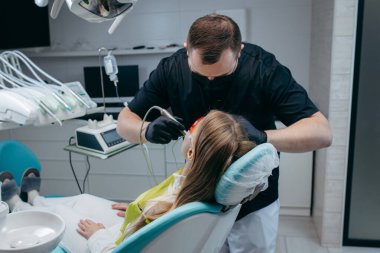 Dişçi bir kıza implant yerleştiriyor.