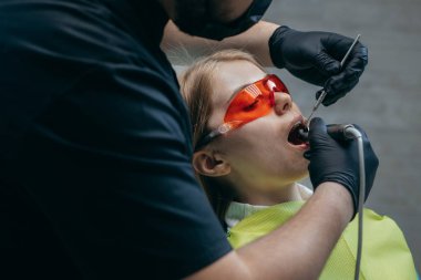 Dişçi bir kıza implant yerleştiriyor.