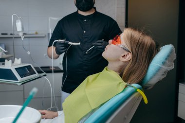 Dişçi bir kıza implant yerleştiriyor.