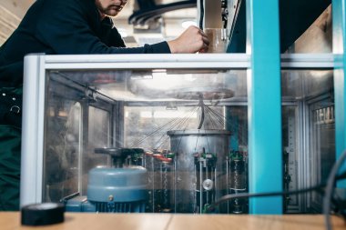 Örgü makinesi üzerinde çalışan bir operatör