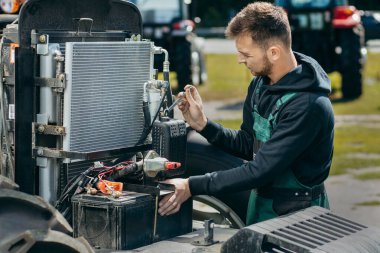 Genç tamirci traktörü dışarıda.