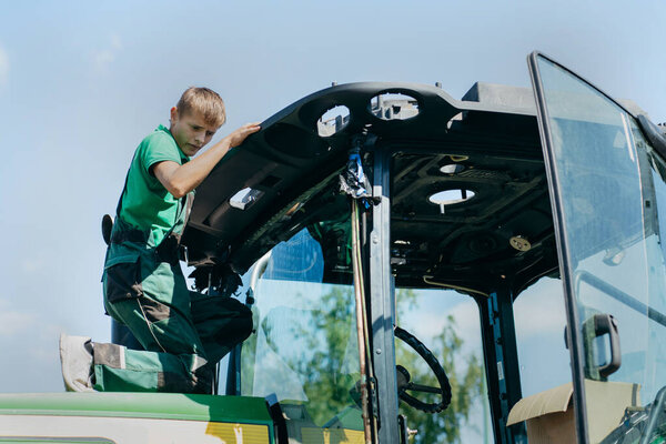 Молодой механический ремонт трактора на открытом воздухе