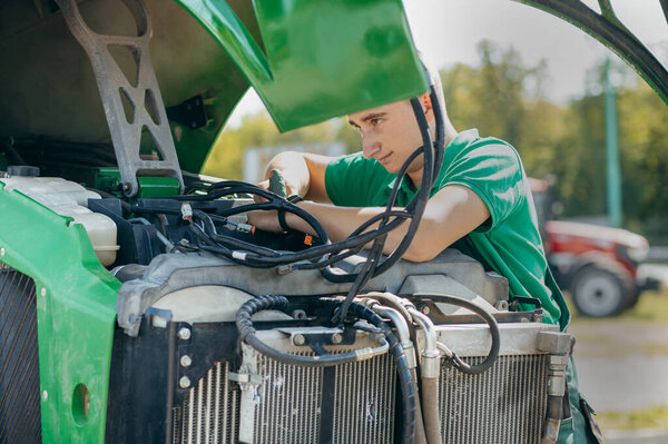 Молодой механический ремонт трактора на открытом воздухе