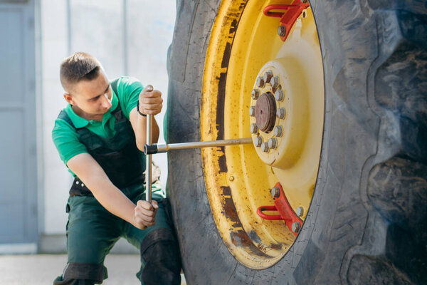 Молодой механический ремонт трактора на открытом воздухе