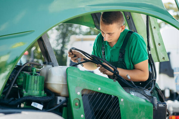 Молодой механический ремонт трактора на открытом воздухе