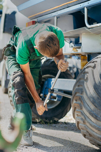 Молодой механический ремонт трактора на открытом воздухе