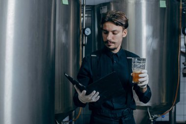 Bira fabrikasındaki bira kalitesini denetleyen gençler