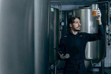 Bira fabrikasındaki bira kalitesini denetleyen gençler