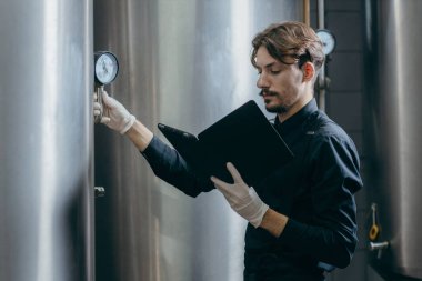 Bira fabrikasında parametreleri denetleyen gençler