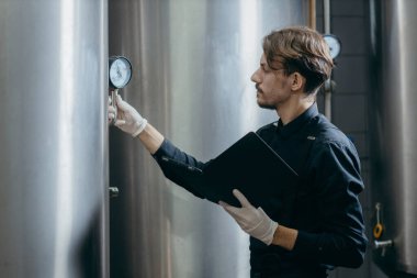 Bira fabrikasında parametreleri denetleyen gençler
