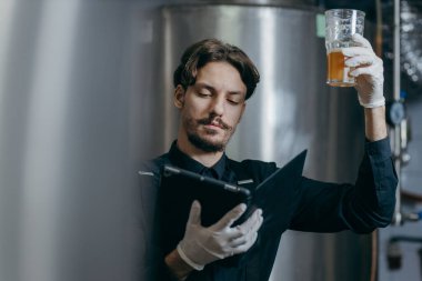 Bira fabrikasındaki bira kalitesini denetleyen gençler
