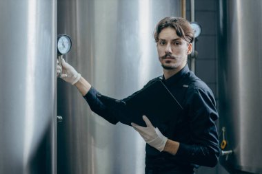Bira fabrikasında parametreleri denetleyen gençler