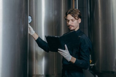 Bira fabrikasında parametreleri denetleyen gençler