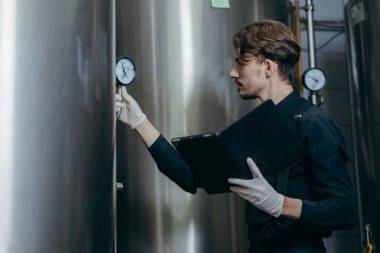 Bira fabrikasında parametreleri denetleyen gençler