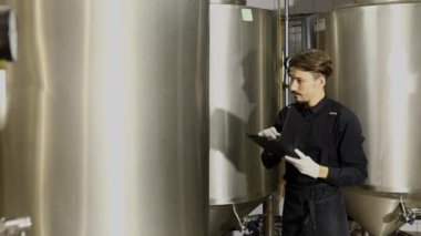 Bira fabrikasında parametreleri denetleyen gençler
