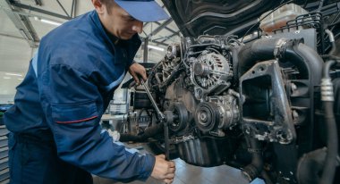 Otomatik tamirci bir motoru tamir eder. Zamanlama zinciri değiştiriliyor